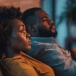 Ele evita Conversa: Como Tocar em Assuntos Delicados Sem Afastar Casal sentado em silêncio no sofá, enfrentando uma conversa difícil no relacionamento